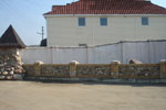 фото 2 видов заборов: кирпичный со вставками из камня и оштукатурненная стена (картинка №45)